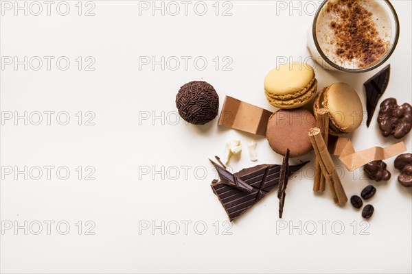 Overhead view macaroons chocolate ball coffee glass white background