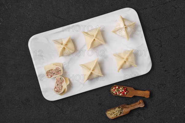 Top view of homemade spicy beef dumplings on marble serving plate