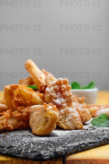 Close up view of deep fried fruits in breading served with caramel and strawberry jam