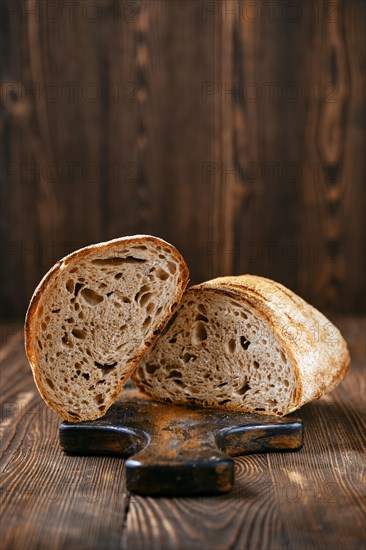 Loaf of artisan sourdough bread with porous texture cut on half