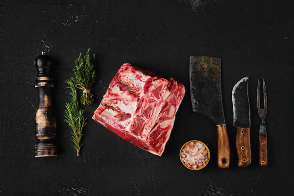 Top view of raw rib-eye steak bone in on dark background