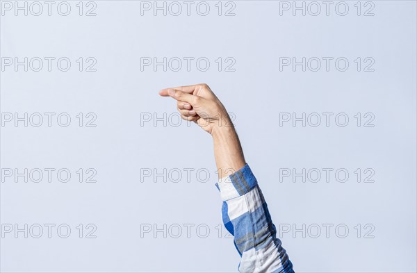 Hand gesturing the letter G in sign language on an isolated background. Man's hand gesturing the letter G of the alphabet isolated. Letters of the alphabet in sign language