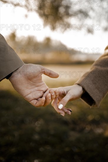 Close up couple holding hands outside