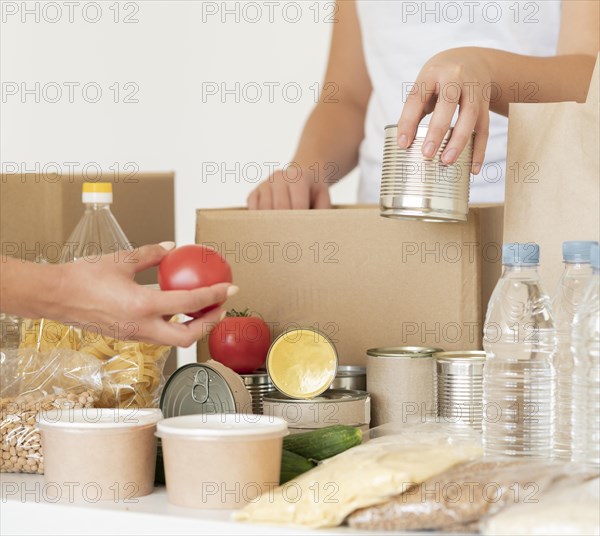 Volunteers putting canned food water donation bag. Resolution and high quality beautiful photo