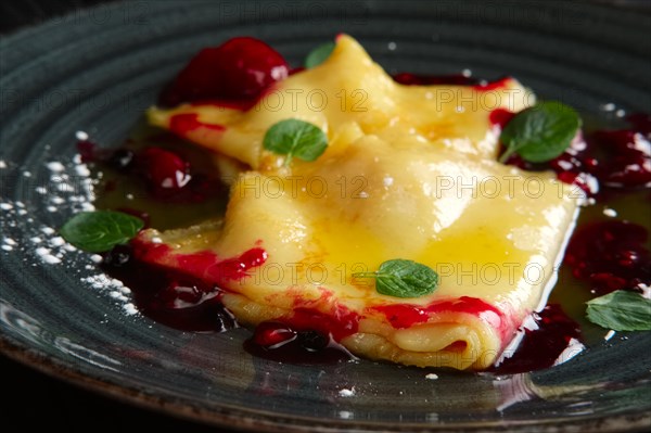 Pancakes with cherry jam decorated with mint leaves