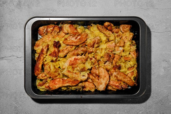 Chicken stripes baked with cheese and onion in oven-tray