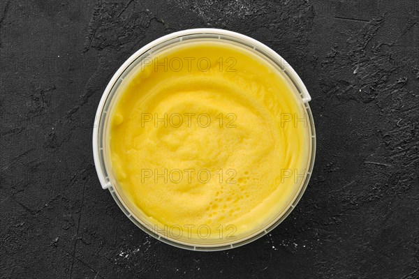 Top view of homemade cream cheese in plastic bowl