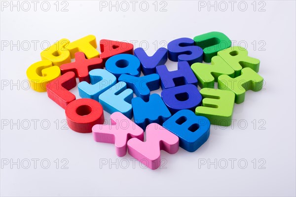 Colorful letter blocks shape heart on white background