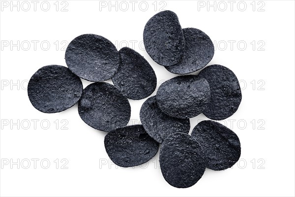 Overhead view of black crispy spicy potato chips isolated on white background