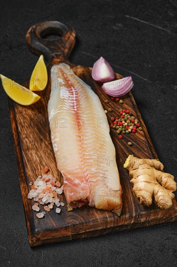 Freshly frozen zander fillet on wooden cutting board