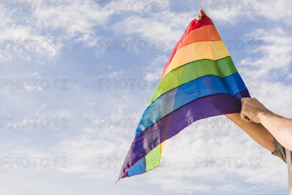 Man with big flag lgbt colors blue sky