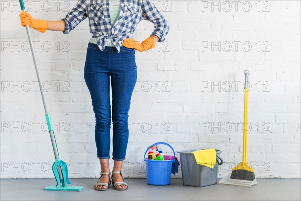 Woman standing front brick wall with cleaning equipments. Resolution and high quality beautiful photo