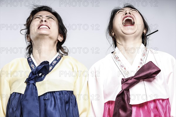 Portrait of two woman in Korean traditional costume with open mouths