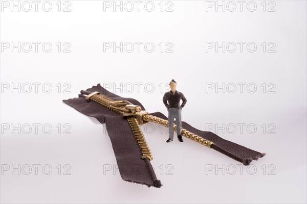 Close up or macro of a brown zipper and a little model man on white background