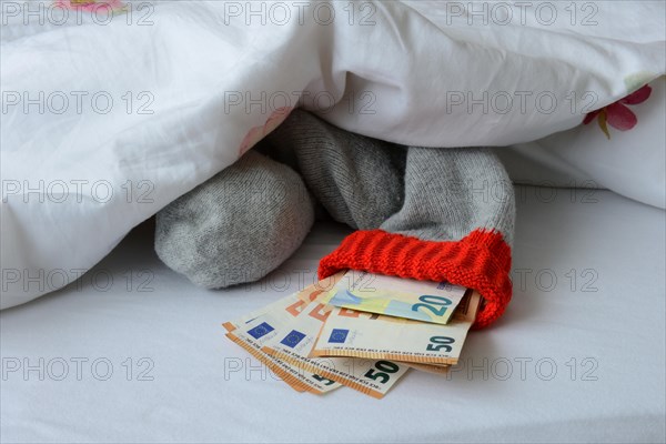 Banknotes in stocking under duvet