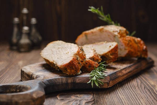 Closeup view of pork collar joint baked in oven on wooden cutting board