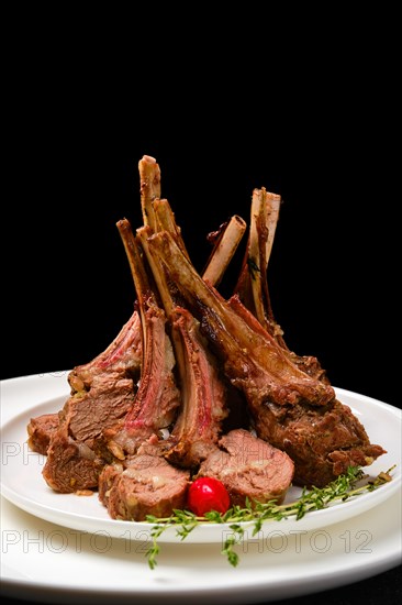 Grilled rack of lamb on a plate with spicy sauce