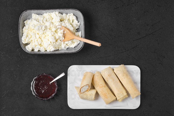 Overhead view of homemade pancakes stuffed with cottage cheese on marble serving plate