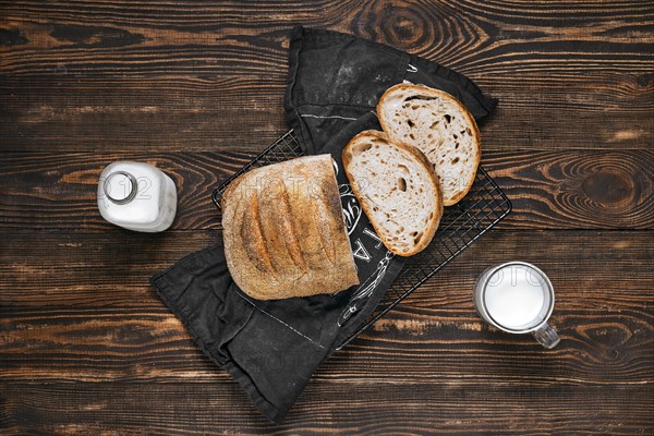 Overhead view of loaf of artisan sourdough bread with porous texture on wooden table