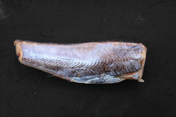 Frozen raw pollock carcass on wooden background