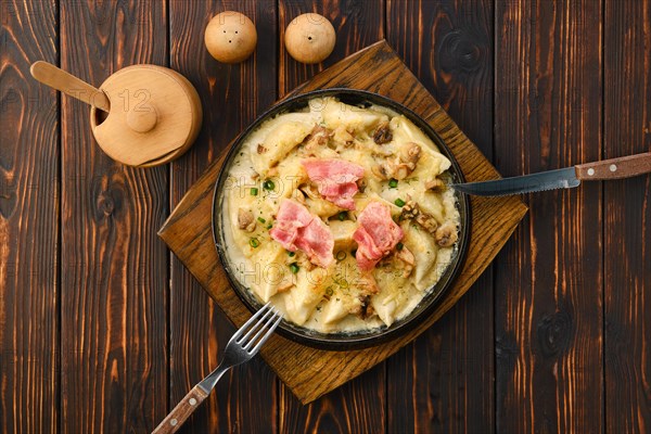 Top view of pan with fried meat dumplings with bacon and mushroom sauce