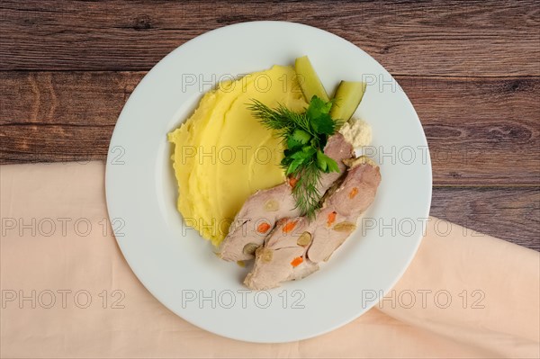 Top view of cold boiled pork with potato puree and pickled cucumber