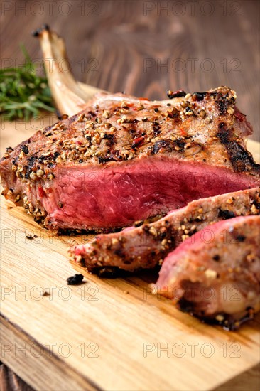 Close up of medium rare cowboy steak on wooden cutting board