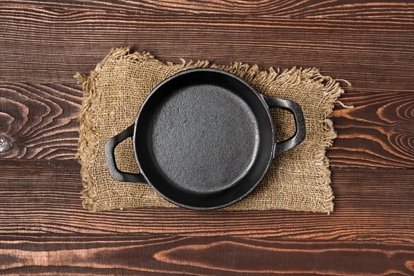 Empty mini cast-iron skillets on wooden table