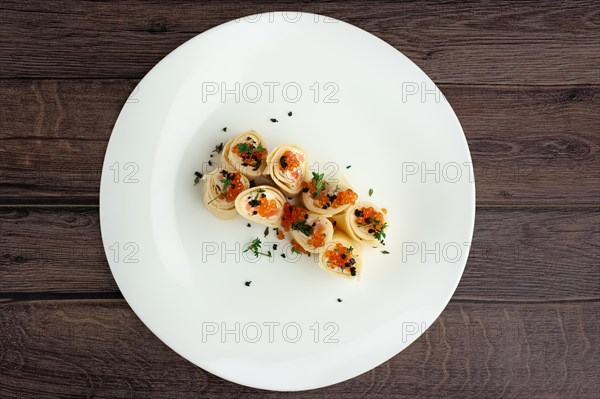 Top view of pancakes with salmon and caviar on big white plate