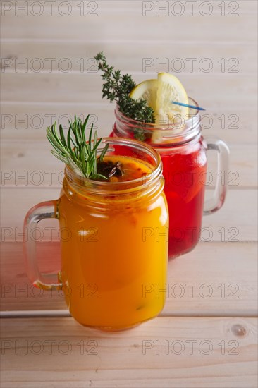 Two cups of cranberry tea and sea buckthorn tea with citrus