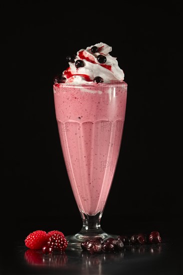 Glass of fruit cocktail on black background