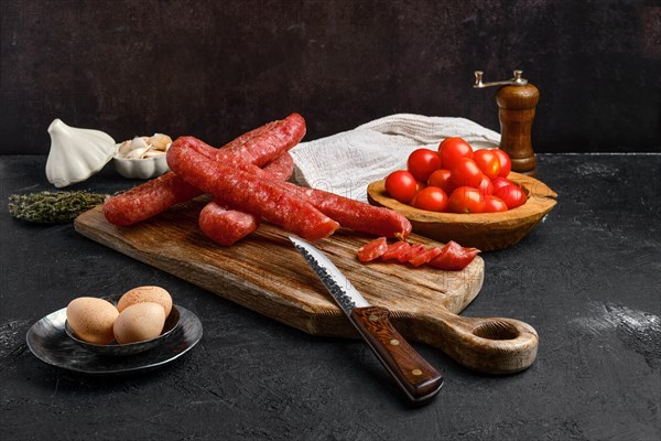 Air dried turkey sausage. Rustic lunch with eggs and tomato