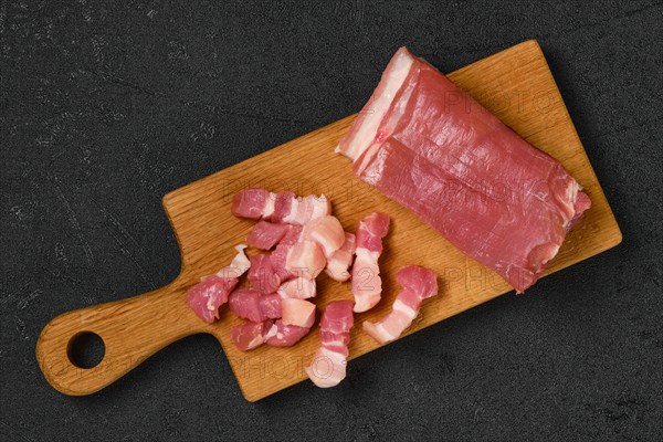 Top view of raw pork belly on wooden cutting board