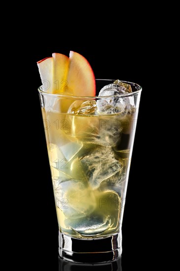 Glass of cold water with ice cubes and apple syrup isolated on black background