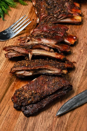 Top view of grilled lamb breast ribs on wooden cutting board