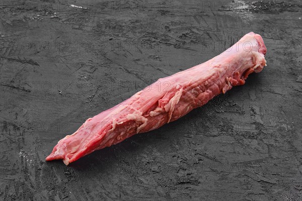 Raw fresh pork fillet on black background