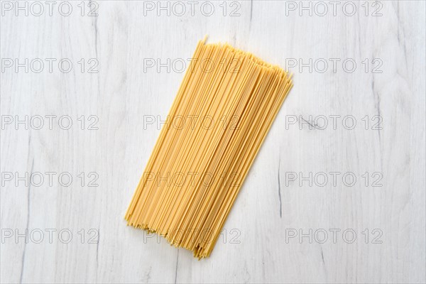 Overhead view of raw spaghetti on wooden table