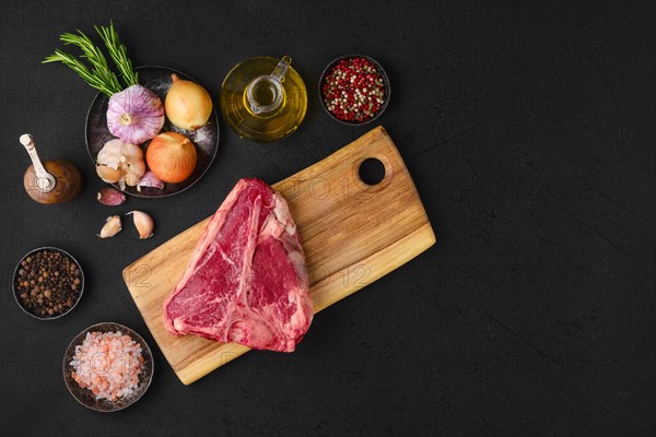 Overhead view of raw porterhouse steak with spice and seasoning ready for cooking