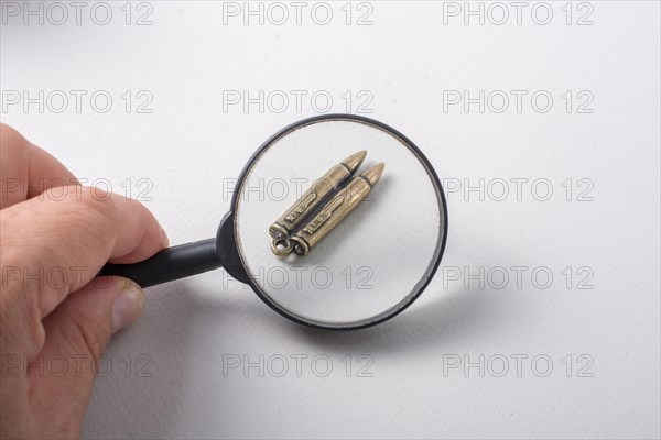 Bullet under magnifying glass as Conceptual against the war photography