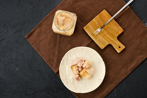 Top view of canned cod liver in glass pot on the table