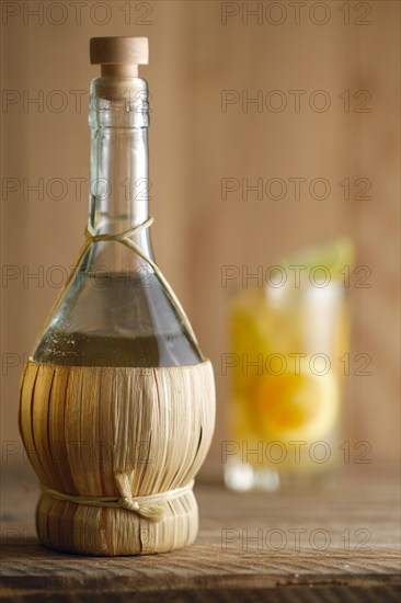 Bottle of homemade Vodka and glass witn orange juice cocktail