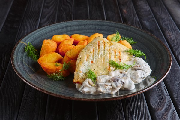 Rustic lunch. Grilled chicken filet with potato balls and creamy mushroom sause