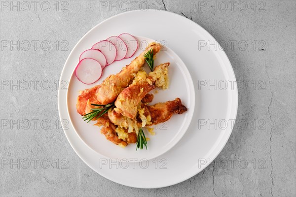 Overhead view of chicken stripes baked with cheese and onion