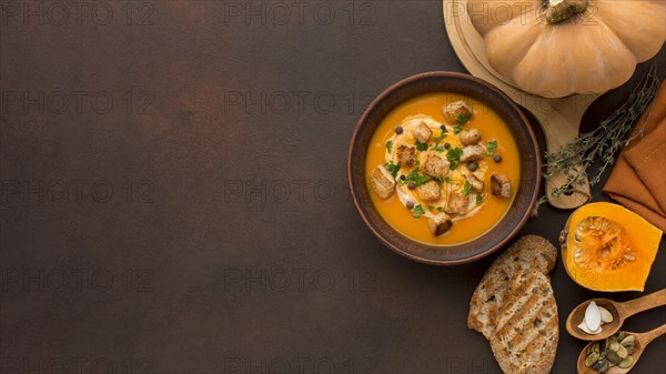 Flat lay winter squash soup with copy space croutons bowl