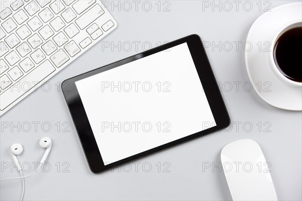 Overhead view keyboard earphone mouse digital tablet coffee cup gray background