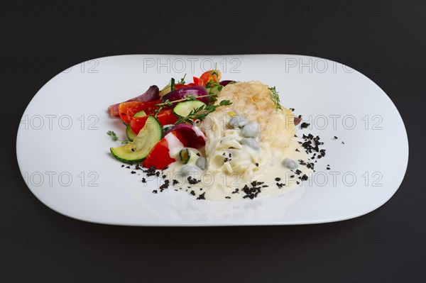 Fish fillet with grilled vegetables under cream sauce