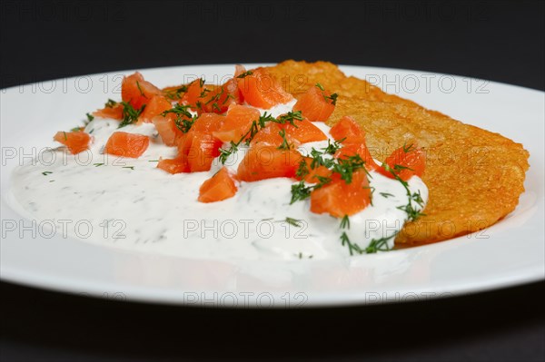 Traditional belorussian potato pancakes with salmon and sour cream