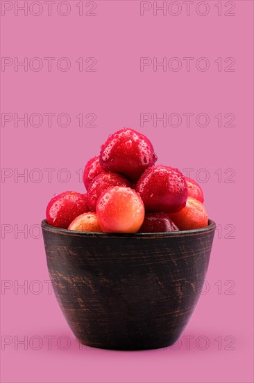 Fresh red cherries in clay bowl