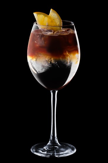 Espresso and tonic cocktail in wine glass isolated on black background