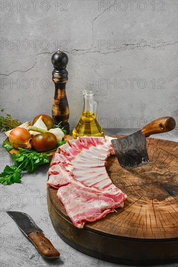 Raw fresh lamb flap ribs with ingredients on wooden log